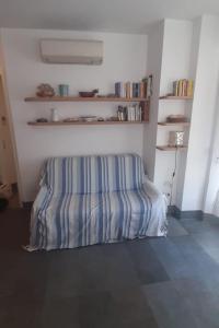 um quarto com um sofá listrado no canto de um quarto em Capraia per te em Ilha Capraia