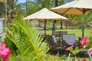 a group of chairs and tables with umbrellas at Ocean Beach Resort & SPA in Malindi