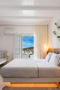 1 dormitorio con 1 cama grande y balcón en Elements Sifnos Boutique, en Faros