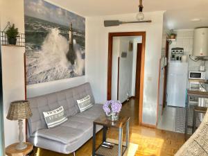 a living room with a couch and a refrigerator at Rincon en el Rio Sella in Ribadesella