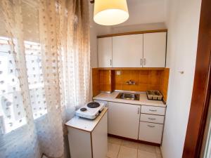 a small kitchen with white cabinets and a sink at Prassas Sea View in Nea Potidaea