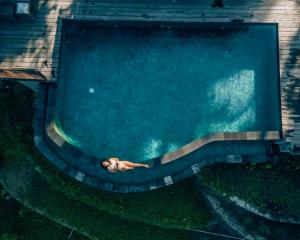 a person swimming in a swimming pool at Angsoka Bungalow in Ubud