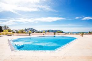duży basen z niebieską wodą na patio w obiekcie L'ANGE GARDIEN AP4269 by Riviera Holiday Homes w mieście Villefranche-sur-Mer