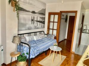 sypialnia z łóżkiem i stołem w pokoju w obiekcie Apartamento con vistas espectaculares al rio Sella w mieście Ribadesella
