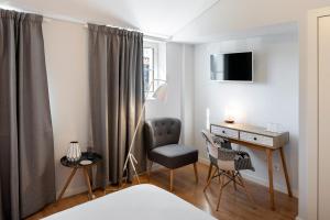 a bedroom with a desk and a chair and a bed at NJOY Coimbra in Coimbra