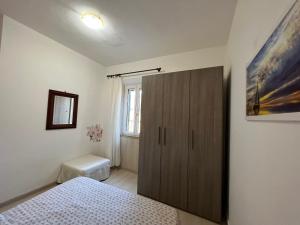 a bedroom with a wooden cabinet and a toilet at Appartamenti Lucry in Procchio