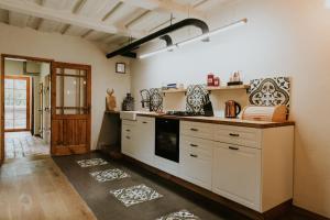 uma cozinha com armários brancos e um fogão em Kalēju ielas rezidence: Talsu vecpilsētas pērle em Talsi