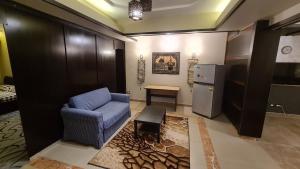 a living room with a blue couch and a refrigerator at The Resort Studio - New Cairo in Cairo