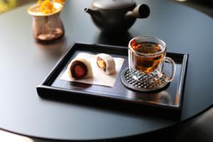 a black tray with a cup of tea on a table at 湯村温泉郷 御宿コトブキ in Yumura