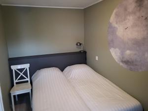 1 dormitorio con 1 cama y una pintura de luna en la pared en Appartement Duinroos Boodtlaan 1K De Koog-Texel, en De Koog