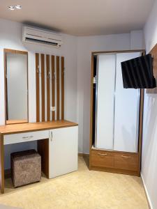 Zimmer mit einem Schreibtisch, einem Spiegel und einem TV. in der Unterkunft Hotel Meta Ksamil in Ksamil