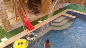a young child in a swimming pool with a slide at The Resort Studio - New Cairo in Cairo