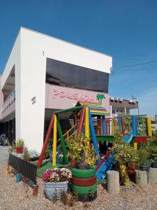 um parque infantil em frente a um edifício com pussas asia em Pousada Rota das Praias em Penha
