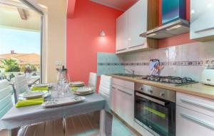 una cucina con pareti rosse e un tavolo con piatti di Apartment Liam a Novigrad Istria