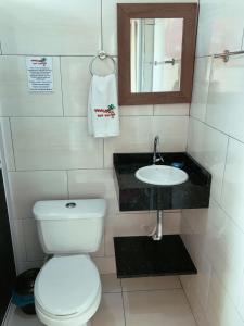 a small bathroom with a toilet and a sink at Pousada Rota das Praias in Penha
