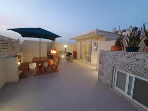 a balcony with a table and an umbrella at B&S Accommodation Penthouse 602 in Hal Ghaxiak