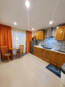 a kitchen with wooden cabinets and a table and chairs at B&S Accommodation Penthouse 602 in Hal Ghaxiak