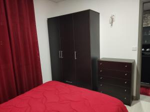 ein Schlafzimmer mit einem roten Bett und einer Kommode in der Unterkunft Maison de vacances et week-end, 2 in Esposende