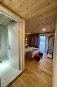 - une chambre avec un lit et une douche en verre dans l'établissement Hotel Chubezeni, à Mestia