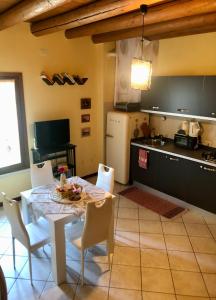 a kitchen with a table and chairs and a kitchen with a refrigerator at Casa Giulia - Tramonto - Valeggio sul Mincio in Valeggio sul Mincio