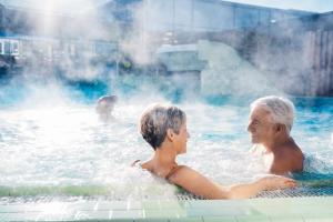 an older woman and child in a hot tub at Seminaris Hotel Lüneburg in Lüneburg