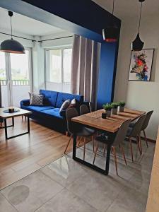 - un salon avec un canapé bleu et une table dans l'établissement Apartament Komfort 17, à Zator