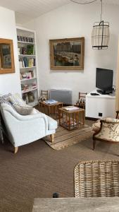 a living room with a couch and a tv at La Terrasse du Bois Plage in Le Bois-Plage-en-Ré