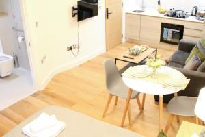 uma cozinha e sala de estar com mesa e cadeiras em Lovely Studio Apartment with access for Wheel-chairs in Sydenham em Forest Hill