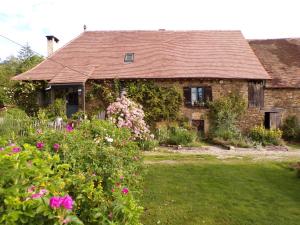 a house with a garden with flowers in front of it at la maison de Royer in Meuzac