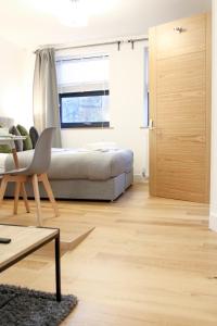 un soggiorno con letto e pavimento in legno di Lovely Studio Apartment with access for Wheel-chairs in Sydenham a Forest Hill