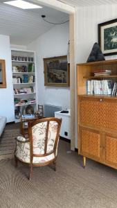 a living room with a chair and a dresser at La Terrasse du Bois Plage in Le Bois-Plage-en-Ré