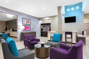 - une salle d'attente avec des chaises violettes et bleues dans l'établissement La Quinta by Wyndham Pharr North McAllen, à Pharr