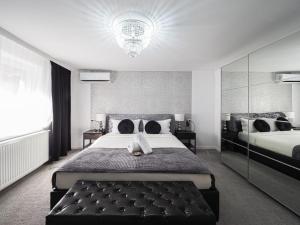 a large bedroom with two beds and a chandelier at For You Apartments Gold & Silver in Sibiu