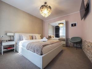 ein Schlafzimmer mit einem großen Bett und einem Kronleuchter in der Unterkunft For You Apartments Gold & Silver in Sibiu