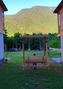 a person sitting on a swing in a yard at Hotel Chubezeni in Mestia