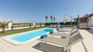 une piscine avec des chaises longues et une piscine dans l'établissement Luxury Villa Cindy, à Caleta de Fuste