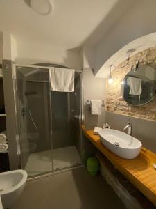 La salle de bains est pourvue d'un lavabo et d'une douche. dans l'établissement Altrelli B&B, à Corato