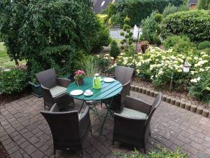 a patio with a table and chairs and flowers at Ferienwohnung Heike in Rabel