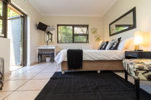 Schlafzimmer mit einem Bett und einem Schreibtisch in der Unterkunft Tyger Classique Self-Catering Cape Town, Tyger Valley in Bellville