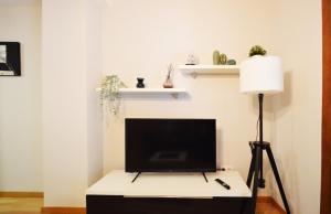 a living room with a tv on a table with a lamp at Apartamento Encanto Tarazona Plaza de España in Tarazona de Aragón +3 photos