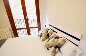 - une chambre avec un lit blanc et une fenêtre dans l'établissement Apartamento Encanto Tarazona Plaza de España, à Tarazona de Aragón