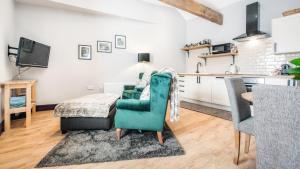 a living room with a green chair and a table at The Old Milking Parlour in Barmston