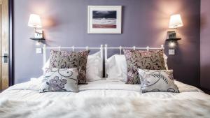a bedroom with a white bed with pillows at The Old Milking Parlour in Barmston