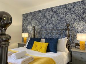 um quarto com uma cama com almofadas azuis e amarelas em The Countryman em St. Ives