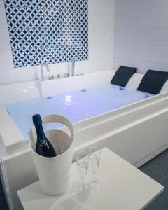 una bottiglia di vino in un secchio di fronte a una vasca da bagno di Hotel & Spa Relais Freedom Club a Massa Lubrense
