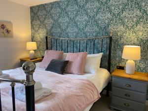 ein Schlafzimmer mit einem Bett und zwei Lampen an Tischen in der Unterkunft The Countryman in St Ives