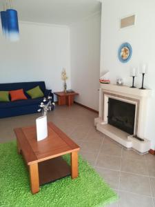 a living room with a table and a fireplace at Casa Campos in Nazaré