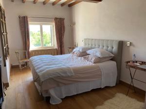 a bedroom with a large white bed with a window at L'Angélus in Genay