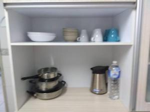 a cupboard with dishes and bowls and a water bottle at 3Rooms 10pax MC 5 star hotel Sofa&Bed MRT McD Axiata in Seri Kembangan