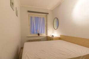 a white bedroom with a bed and a window at Edelweiss 0407 in Middelkerke